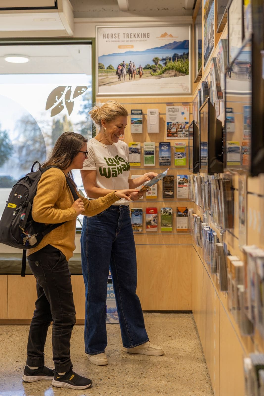 A visitor and guide browsing the brochure wall