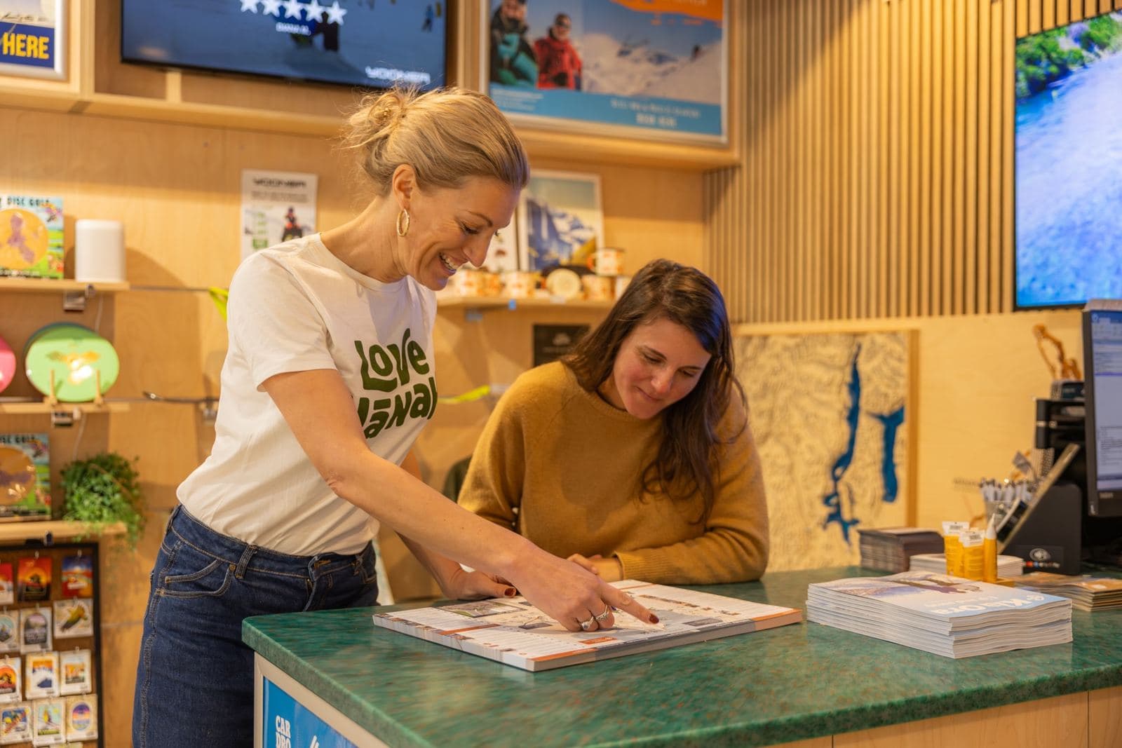 Guide helping a visitor plan at the counter